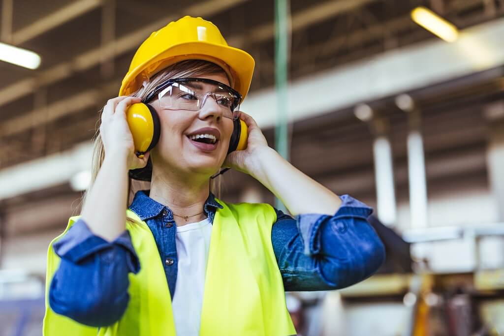 Radnica stavlja zaštitne slušalice i kacigu