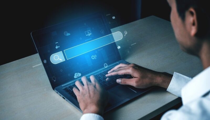 Osoba istražuje podatke na laptopu uz digitalne prikaze analize tržišta