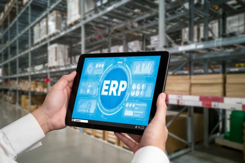 Zaposleni koristi tablet sa ERP sistemom u modernom skladištu