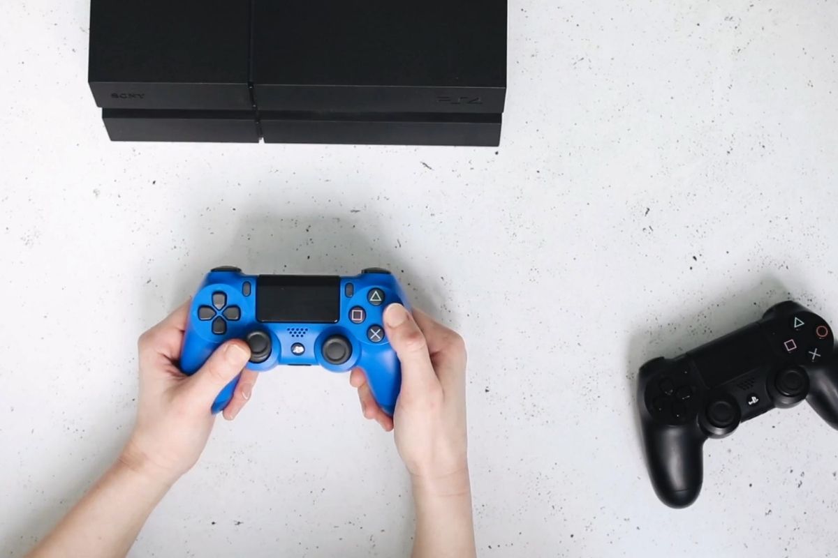 prikaz gaming konzole sa dzojsticima u ruci kod momka
