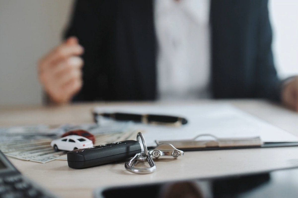 prikaz ključa od automobila, makete automobila, novca i papira sa čovekom u pozadini